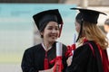 Two Asian young beautiful graduate female students with master and bachelor degree standing smiling and holding diploma in hand Royalty Free Stock Photo