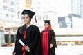 Two Asian young beautiful graduate female students with master and bachelor degree walking in the line and holding diploma in hand Royalty Free Stock Photo
