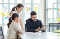 Two Asian young beautiful professional successful businesswoman employees presenting showing paperwork document on clipboard to Royalty Free Stock Photo