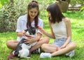 two asian young beautiful woman playing with french bulldog puppy in park outdoor Royalty Free Stock Photo