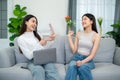 Two asian young women having fun together while sitting on the sofa in the living room Royalty Free Stock Photo