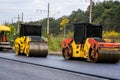 Two asphalt rollers compacting fresh pavement during road construction project Royalty Free Stock Photo