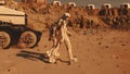 Two astronauts walk toward scientific base on Mars