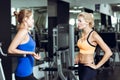 Two athletic blond women talking in the gym. Girl communicates with trainer Royalty Free Stock Photo