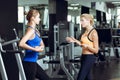 Two athletic blond women talking in gym. Girl communicates with trainer Royalty Free Stock Photo