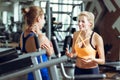 Two athletic blond women talking in gym. Girl communicates with trainer Royalty Free Stock Photo