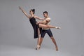 Two athletic modern ballet dancers are posing against a gray studio background. Royalty Free Stock Photo