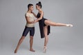 Two athletic modern ballet dancers are posing against a gray studio background. Royalty Free Stock Photo