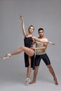 Two athletic modern ballet dancers are posing against a gray studio background. Royalty Free Stock Photo