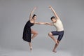 Two athletic modern ballet dancers are posing against a gray studio background. Royalty Free Stock Photo