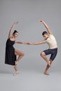 Two athletic modern ballet dancers are posing against a gray studio background. Royalty Free Stock Photo