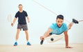 Two athletic squash players playing match during competitive court game. Fit active mixed race and caucasian athlete Royalty Free Stock Photo