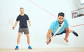 Two athletic squash players playing match during competitive court game. Fit active mixed race and caucasian athlete Royalty Free Stock Photo