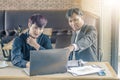 Two attractive businessmen having a meeting with laptop while having coffee