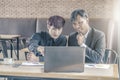 Two attractive businessmen having a meeting with laptop while having coffee