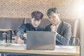 Two attractive businessmen having a meeting with laptop while having coffee