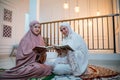 two attractive girls wearing hijab reciting the Quran