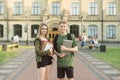 Two attractive happy college students talking at campus park holding copybooks and laptop. Smiling joyful cheerful student couple Royalty Free Stock Photo