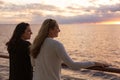 Two Attractive middle-aged women enjoying the sunset view from the deck of a cruise ship Royalty Free Stock Photo