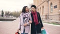 Two attractive mixed race women with shopping bags talking and walking down the street. Girlfriends have fun after Royalty Free Stock Photo