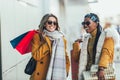 Attractive multiethnic young women holding shopping bags and smiling