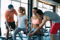 Two attractive women exercising with personal trainers