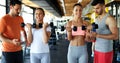 Two attractive women exercising with personal trainers