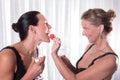 Two attractive women - one is feeding the other with strawberry Royalty Free Stock Photo