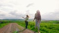 Two attractive women runing and wirl across a green field.