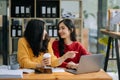 Two Attractive young Asian female college students working on the school project using laptop computer and tablet together, enjoy Royalty Free Stock Photo