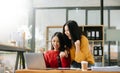 Two Attractive young Asian female college students working on the school project using laptop computer and tablet together, enjoy Royalty Free Stock Photo