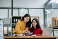 Two Attractive young Asian female college students working on the school project using laptop computer and tablet together, enjoy Royalty Free Stock Photo