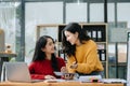 Two Attractive young Asian female college students working on the school project using laptop computer and tablet together, enjoy Royalty Free Stock Photo