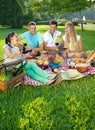 Two couples picnicking in a park