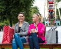 Two attractive young female friends enjoying a day out after successful shopping Royalty Free Stock Photo