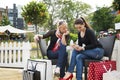 Two attractive young female friends enjoying a day out after successful shopping Royalty Free Stock Photo