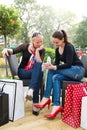 Two attractive young female friends enjoying a day out after successful shopping Royalty Free Stock Photo