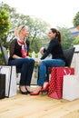 Two attractive young female friends enjoying a day out after successful shopping Royalty Free Stock Photo