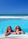 Two attractive young girls in a swimming pool on the beach