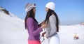 Two attractive young women chatting in the snow Royalty Free Stock Photo