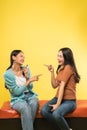 two attractive young women laughing and pointing at each other while joking Royalty Free Stock Photo