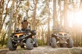 Two atv riders in helmets raise their hands up Royalty Free Stock Photo