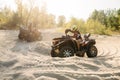 Two atv riders in helmets ride in a circle on sand Royalty Free Stock Photo