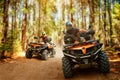 Two atv riders, speed race in forest, front view Royalty Free Stock Photo