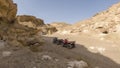 Two ATVs in the gorge against the backdrop of the mountains on a hot sunny day Royalty Free Stock Photo