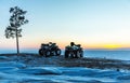 Two ATVs at sunset over the frozen north sea Royalty Free Stock Photo