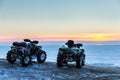 Two ATVs at sunset over the frozen north sea Royalty Free Stock Photo