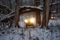 Two ATVs on wheels with headlights on ride through a snowy forest. Royalty Free Stock Photo