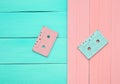 Two audio cassettes on a blue pink wooden pastel background. Royalty Free Stock Photo