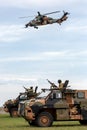 Two Australian Army Bushmaster armoured Personnel carriers APC with an Army Eurocopter Tiger helicopter providing air cover